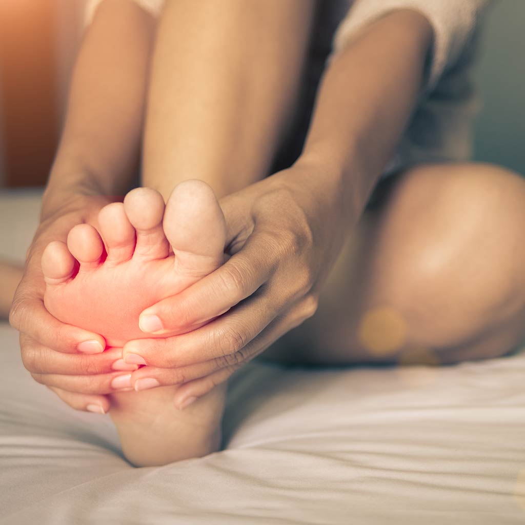 Showing Someone Hold the foot with Hands because of Foot Pain